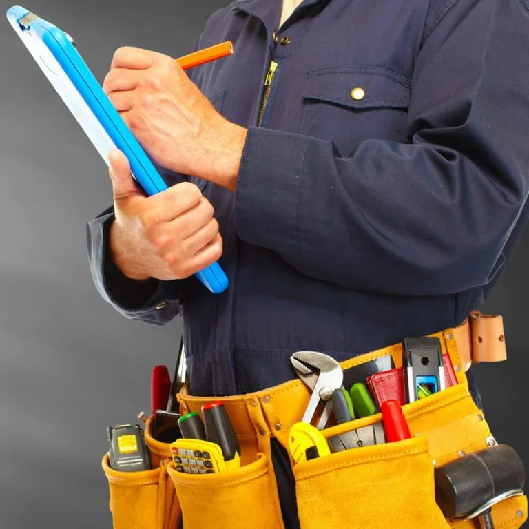 Handwerker mit Werkzeuggürtel bei der Objektbegehung