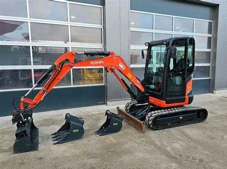 Minibagger mit verschiedenen Löffeln vor einer Halle